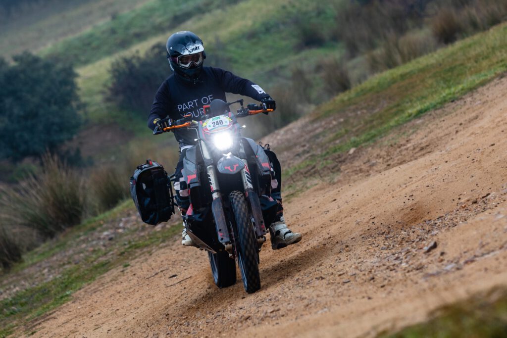 Moto KTM 890 Rally equipada con maletas Sysbag WP L de SW-Motech, rodando por un sendero de tierra en un entorno rural